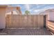 Wooden fence with metal gate provides backyard privacy at 14493 S Country Club Dr, Arizona City, AZ 85123