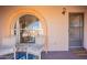 Cozy front porch with seating, complemented by a decorative arched window and a welcoming entryway at 14493 S Country Club Dr, Arizona City, AZ 85123