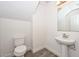 Modern half-bath with white toilet, white pedestal sink and wood floors at 1510 E Red Range Way, Phoenix, AZ 85085