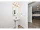 Modern half-bath with white pedestal sink and wood floors near entry to kitchen at 1510 E Red Range Way, Phoenix, AZ 85085