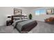 Staged bedroom featuring a cozy bed with neutral toned decor, lamps, chair, and artwork at 1510 E Red Range Way, Phoenix, AZ 85085