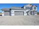 Two-story home featuring a three-car garage and gray and white color scheme with stone accents in a desert setting at 1510 E Red Range Way, Phoenix, AZ 85085