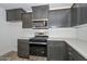 Close-up of modern kitchen featuring gray cabinets, stainless steel appliances, and white countertops at 1510 E Red Range Way, Phoenix, AZ 85085