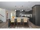 Modern kitchen featuring gray cabinets, white countertops, stainless steel appliances, hardwood floors and staged stools at 1510 E Red Range Way, Phoenix, AZ 85085