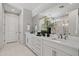 Primary bathroom with double vanity, white cabinets and a large mirror at 17192 W Rocklin St, Surprise, AZ 85388