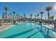 A resort-style community pool surrounded by tall palm trees and comfortable lounge chairs on a sunny day at 17192 W Rocklin St, Surprise, AZ 85388