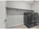 Modern laundry room with front loading washer and dryer and shelf at 17192 W Rocklin St, Surprise, AZ 85388