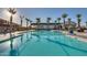 Resort style pool with multiple buildings, palm trees and comfortable patio furniture at 17192 W Rocklin St, Surprise, AZ 85388