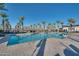 Resort style pool surrounded by tall palm trees and comfortable patio furniture at 17192 W Rocklin St, Surprise, AZ 85388