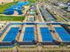 Aerial view of multiple blue tennis courts in a well-maintained community with beautiful landscaping at 17192 W Rocklin St, Surprise, AZ 85388