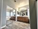 Bathroom featuring double sinks, a large mirror, and a soaking tub reflected in the mirror at 17420 W Mohave St, Goodyear, AZ 85338