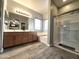 Bathroom featuring wood-look flooring, dual sinks, a soaking tub, and a glass enclosed shower at 17420 W Mohave St, Goodyear, AZ 85338