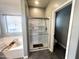 Bathroom featuring a soaking tub and enclosed glass shower with a white tile surround at 17420 W Mohave St, Goodyear, AZ 85338