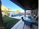 View of the pool from under the covered patio, features beautiful waterfalls and a spacious backyard at 17420 W Mohave St, Goodyear, AZ 85338