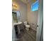 Cozy half-bathroom with a pedestal sink, neutral paint and a window for natural light at 1743 W Pollack St, Phoenix, AZ 85041