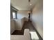 Carpeted upstairs hallway with a gray color palette leading to a bathroom and side window at 1743 W Pollack St, Phoenix, AZ 85041