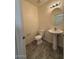 Half bathroom with a pedestal sink, updated lighting, and tile floors at 1745 W Pollack St, Phoenix, AZ 85041