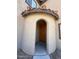 Close up of the entrance to the home with an arched doorway, tile accents and a wood door at 1745 W Pollack St, Phoenix, AZ 85041