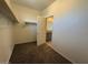 Spacious walk-in closet that leads into the bathroom features ample shelving, and a neutral color palette at 1745 W Pollack St, Phoenix, AZ 85041