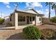 Rear of the home featuring desert landscaping, covered back porch, and palm tree at 17813 W Primrose Ln, Surprise, AZ 85374