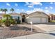 Inviting single-story home with desert landscaping, blue shutters, and a two-car garage at 17813 W Primrose Ln, Surprise, AZ 85374