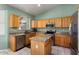 Well-lit kitchen features granite countertops, stainless appliances, and light wood cabinets at 17813 W Primrose Ln, Surprise, AZ 85374