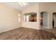 Open-concept living room with wood floors, large window, and seamless flow to the kitchen at 17813 W Primrose Ln, Surprise, AZ 85374