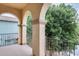 Balcony with views of lush trees and a neighborhood house with columns adding architectural interest at 18256 W Carol Ave, Waddell, AZ 85355