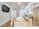 Spacious bathroom featuring a large bathtub, glass-enclosed shower, tan marble flooring, and marble countertops at 18256 W Carol Ave, Waddell, AZ 85355