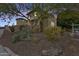 Charming two-story home with stucco facade, gated courtyard, and desert landscaping at dusk at 18256 W Carol Ave, Waddell, AZ 85355