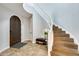 Inviting foyer featuring a curved staircase, tile flooring, and arched front door at 18256 W Carol Ave, Waddell, AZ 85355