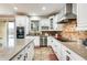 Modern kitchen with stainless steel appliances, granite countertops, and white cabinetry at 18256 W Carol Ave, Waddell, AZ 85355