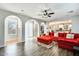 Open-concept living room with hardwood floors, a red sofa, and arched doorways at 18256 W Carol Ave, Waddell, AZ 85355