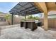 Outdoor kitchen and bar area with a pergola, ideal for entertaining in style at 18256 W Carol Ave, Waddell, AZ 85355