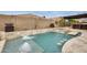 Sparkling pool with water features and travertine tile, creating a serene backyard oasis at 18256 W Carol Ave, Waddell, AZ 85355