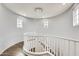 Staircase featuring a modern chandelier, white railing, and wood flooring at 18256 W Carol Ave, Waddell, AZ 85355