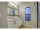 Bright bathroom with a sink, vanity, mirror, and window at 18359 N 88Th Ave, Peoria, AZ 85382