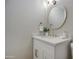 Bright bathroom featuring a white vanity, gold fixtures, round mirror, and a neutral colored wall at 18359 N 88Th Ave, Peoria, AZ 85382