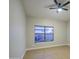 Empty bedroom featuring a window and a ceiling fan at 18359 N 88Th Ave, Peoria, AZ 85382