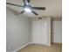 This bedroom features neutral walls, wood floors, a ceiling fan, and a closet with sliding white doors at 18359 N 88Th Ave, Peoria, AZ 85382