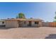 Tan single-story house with a gravel yard, brick accents, and a simple desert landscape at 1841 N Wilbur Cir, Mesa, AZ 85201