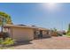 Tan single-story house with a gravel yard and brick accents under a clear blue sky at 1841 N Wilbur Cir, Mesa, AZ 85201