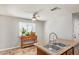 Open kitchen layout with stainless steel sink, island, and breakfast nook bathed in sunlight at 1841 N Wilbur Cir, Mesa, AZ 85201