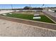 View of cornhole setup on artificial turf, with gravel border and benches at 18763 N Avelino Dr, Maricopa, AZ 85138