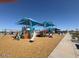 The community playground features a variety of play structures under shaded awnings, ensuring fun for children at 18783 N Avelino Dr, Maricopa, AZ 85138