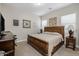 Comfortable bedroom with a large, wood-framed bed, a desk, and neutral decor at 1899 E Everglade Ln, Gilbert, AZ 85298