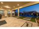 Covered patio with travertine flooring that overlooks the backyard swimming pool with water feature at 1899 E Everglade Ln, Gilbert, AZ 85298