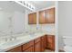 Bathroom featuring double sinks, wood cabinets, a large mirror, and tiled flooring at 1911 E Hartford Ave, Phoenix, AZ 85022