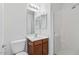 Bathroom with wood vanity, sink, toilet and shower with glass door at 1911 E Hartford Ave, Phoenix, AZ 85022