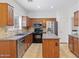 Kitchen with stainless appliances, stone backsplash, tile floors and cherry wood cabinets at 1911 E Hartford Ave, Phoenix, AZ 85022